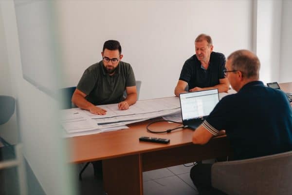 3 collega's van de dienst calculatie zitten samen in bespreking over een industriebouw van edibo.