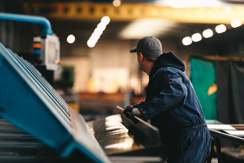 Een edibo-medewerker is bezig met bouwmaterialen te verzagen voor industriebouw.