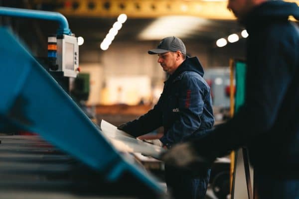Een edibo-medewerker is bezig met bouwmaterialen te verzagen voor industriebouw.